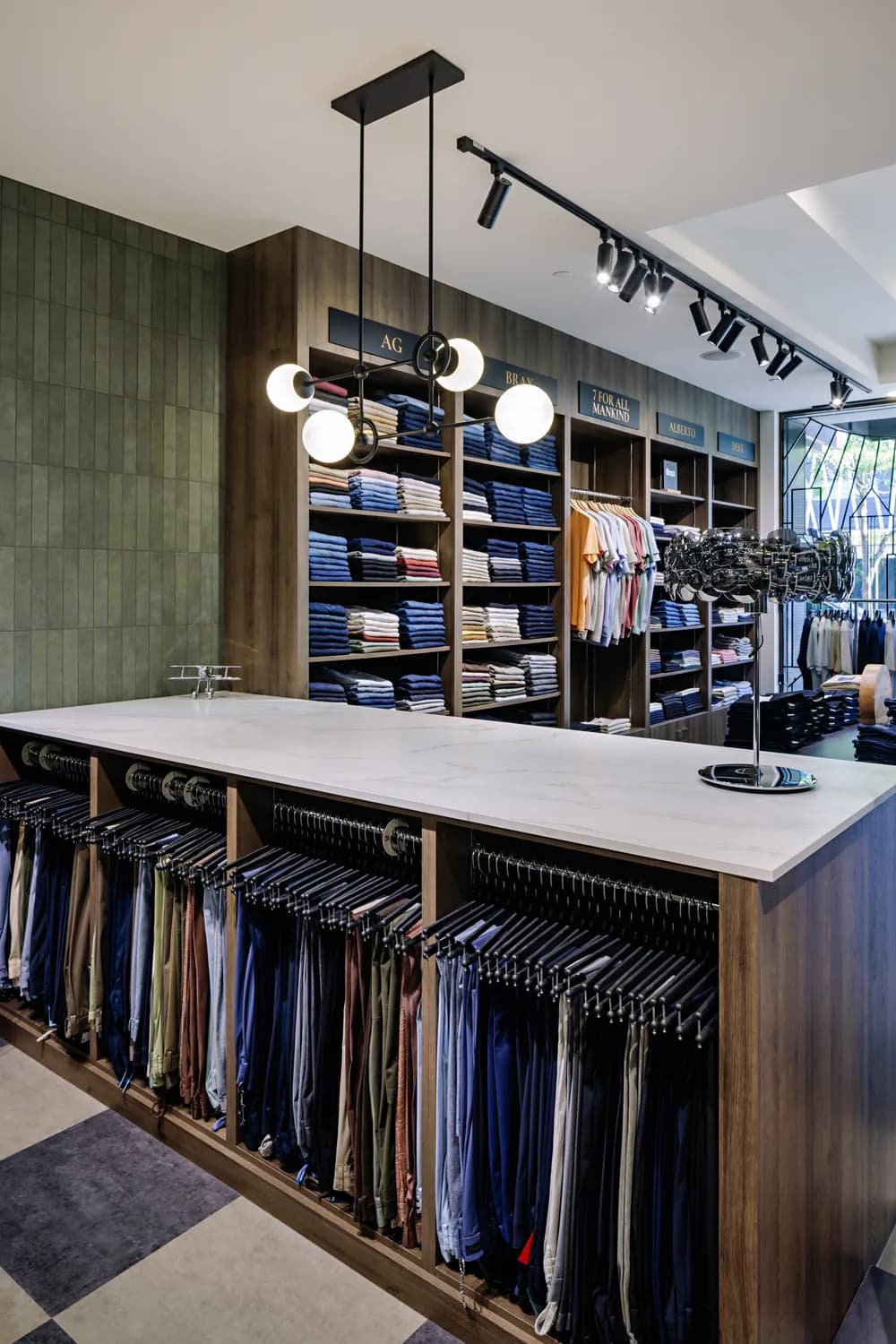 A rail of tailored jackets against a dark green wall
